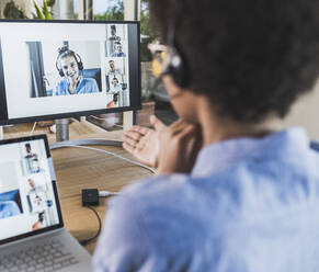 Woman having video conference with coworkers via laptop at home - UUF22489