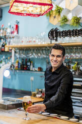 Porträt eines gutaussehenden Barkeepers, der Bier serviert - DLTSF01492