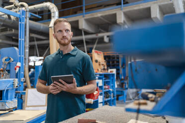 Porträt eines Schreiners in einer Produktionshalle mit einem digitalen Tablet in der Hand - DIGF14274