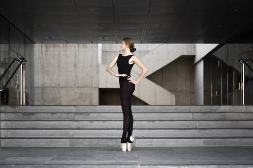 Ballerina in schwarzem Trikot in modernem Betongebäude - JPTF00635