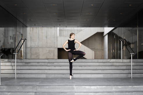 Ballerina in schwarzem Trikot in modernem Betongebäude - JPTF00636