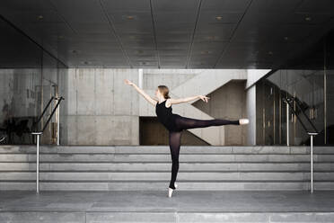 Ballerina in schwarzem Trikot in modernem Betongebäude - JPTF00637