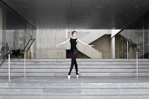 Ballerina in schwarzem Trikot in modernem Betongebäude - JPTF00641