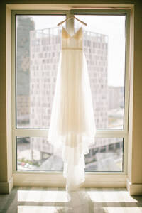 Ein weißes Hochzeitskleid hing auf dem Bügel. - CAVF91659