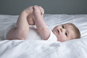 Kleiner Junge auf dem Bett liegend - ISPF00014