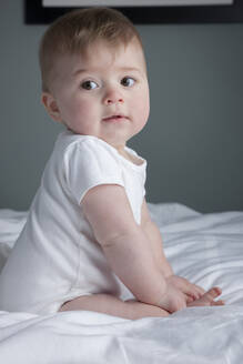 Baby boy sitting on bed - ISPF00017