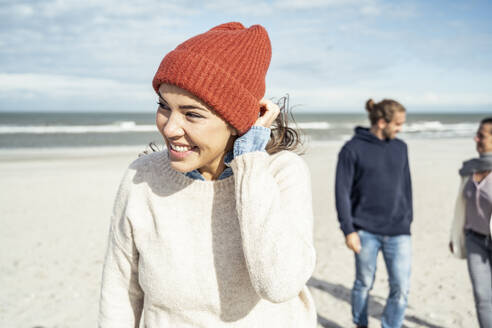 Portrait of woman knit hat standing on beach - UUF22500