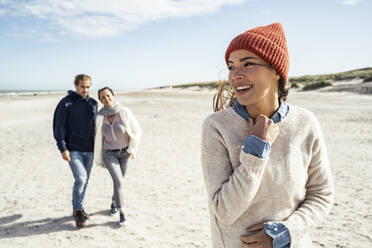 Porträt einer Frau mit Strickmütze am Strand - UUF22503