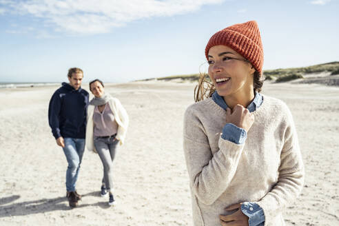 Portrait of woman wearing knit hat standing on beach - UUF22503