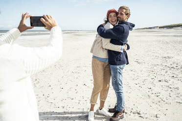 Eine Gruppe von Freunden macht Smartphone-Fotos am Sandstrand - UUF22515