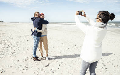 Eine Gruppe von Freunden macht Smartphone-Fotos am Sandstrand - UUF22516