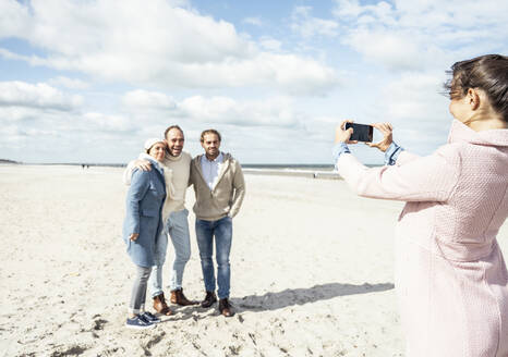 Eine Gruppe von Freunden macht Smartphone-Fotos am Strand - UUF22562