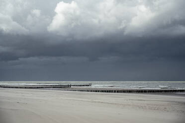 Sturmwolken über leerem Küstenstrand - UUF22578