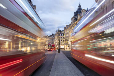 UK, London, Rote Doppeldeckerbusse auf der Oxford Street in der Abenddämmerung, unscharf - WPEF03863