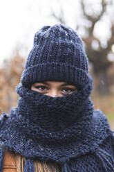 Young woman in knit hat and scarf outdoors - JAQF00164