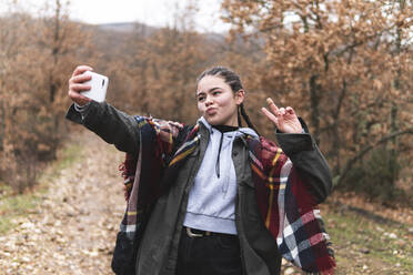 Teenage girl taking selfie in Autumn landscape - JAQF00171