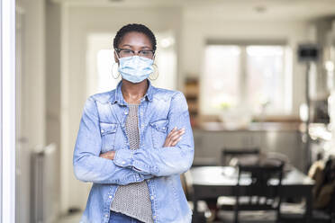 Portrait of woman in face mask at home - WPEF03896