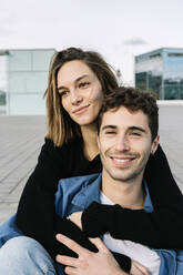 Smiling couple embracing in city - XLGF00973