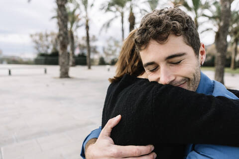 Young couple embracing outdoors stock photo