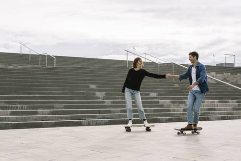 Junges Paar auf dem Skateboard in der Nähe von Stufen - XLGF00997