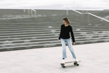 Junge Frau auf dem Skateboard in der Nähe der Treppe - XLGF01001