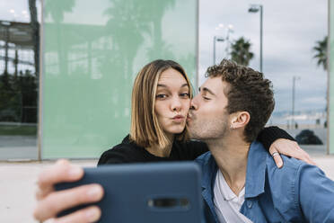 Smiling couple taking selfie outdoors - XLGF01007