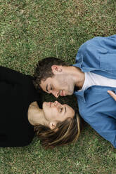 Lächelndes Paar auf dem Rasen liegend - XLGF01017