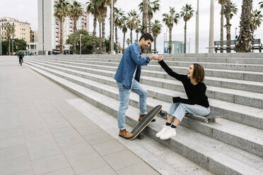 Paar mit Skateboards Fauststöße im Freien - XLGF01027