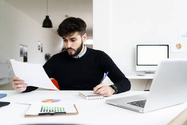 Geschäftsmann arbeitet am Schreibtisch im Büro - GIOF10606