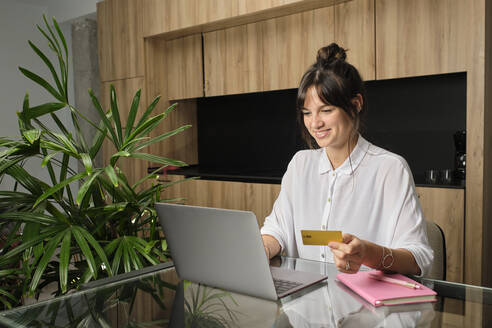 Portrait of young woman shopping online at home - AODF00269