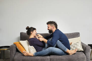 Erwachsenes Paar sitzt zusammen auf dem Sofa - AODF00271