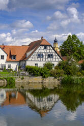 Germany, Bavaria, Wassertrudingen, Wornitzpark watermill reflecting in Wornitz River - LBF03306