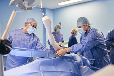 Ein Ärzteteam arbeitet im Operationssaal eines Krankenhauses - SASF00139