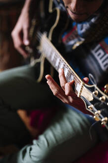 Junger Mann spielt Gitarre zu Hause - JCMF01810