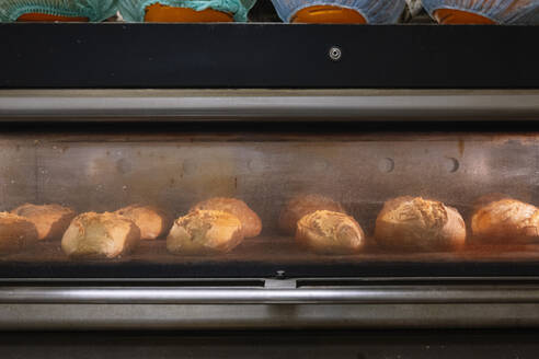 Breads getting baked in oven at bakery - JCMF01815