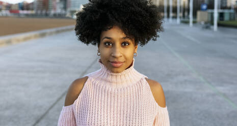 Beautiful woman with afro hair standing on street - MGOF04645