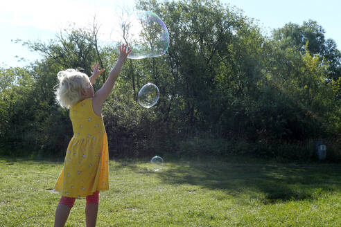 Germany, Schleswig Holstein, Heidkate, Child playing with soap bubbles - GISF00731