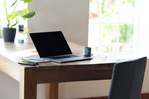 Smartphone und Laptop auf dem Tisch im Heimbüro - SBOF02363