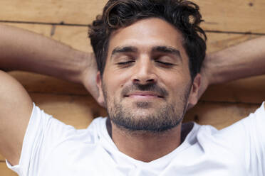 Man smiling while relaxing on floor at home - SBOF02367