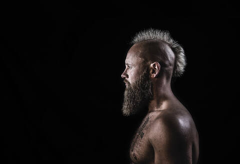 Male viking with mohawk hairstyle standing against black background - KBF00687