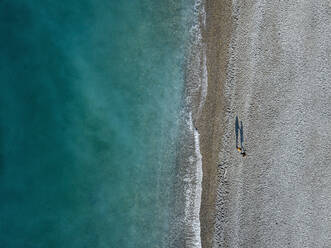 Georgia, Abkhazia, Gagra, Aerial view of Black Sea coastline and people on beach - KNTF06134