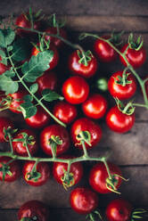 Rote Kirschtomaten auf hölzernem Hintergrund - CAVF91709