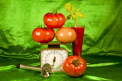 Frische Tomaten auf der Waage durch gesunden Saft gegen grünen Stoff - ERRF04890