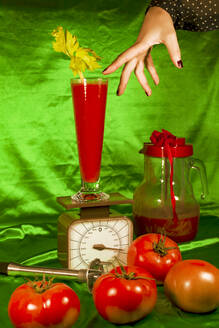 Hand durch Glas Saft auf Waage um frische Tomaten - ERRF04892