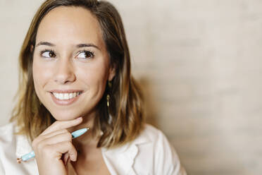 Close-up of thoughtful businesswoman looking away against wall - JCZF00465