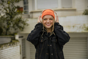 Happy woman in braided hair enjoying music through headphones - ACPF01043