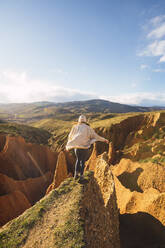 Young woman standing on Carcavas against sky at Valdepenas de la Sierra, Spain - RSGF00498