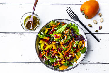 Mixed lettuce with bell pepper, feta, pistachios, tomatoes, pomegranate seeds, persimmon and dressing - SARF04650