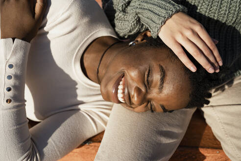 Smiling friend lying on friend lap outdoors - RCPF00564