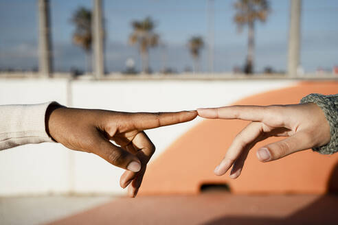 Close-up of friends index finger pointing each other outdoors - RCPF00565